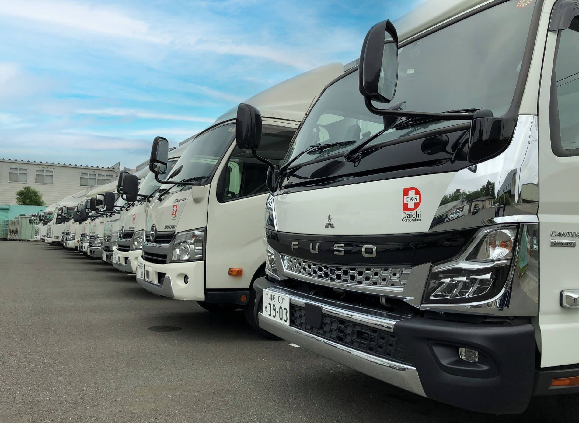 会社のトラックが並んでいる写真